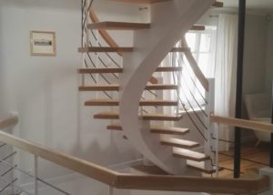 Dębowe schody gięte samonośne na drewnianej belce centralnej