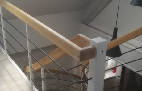 Dębowe schody gięte samonośne na drewnianej belce centralnej